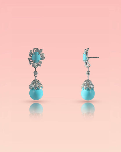 Front and side profile of 92.5 sterling silver drop earrings featuring real turquoise stones and a cz floral halo on a pink background.
