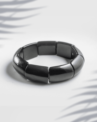 Glossy black rectangular tile fashion bracelet on a white background.
