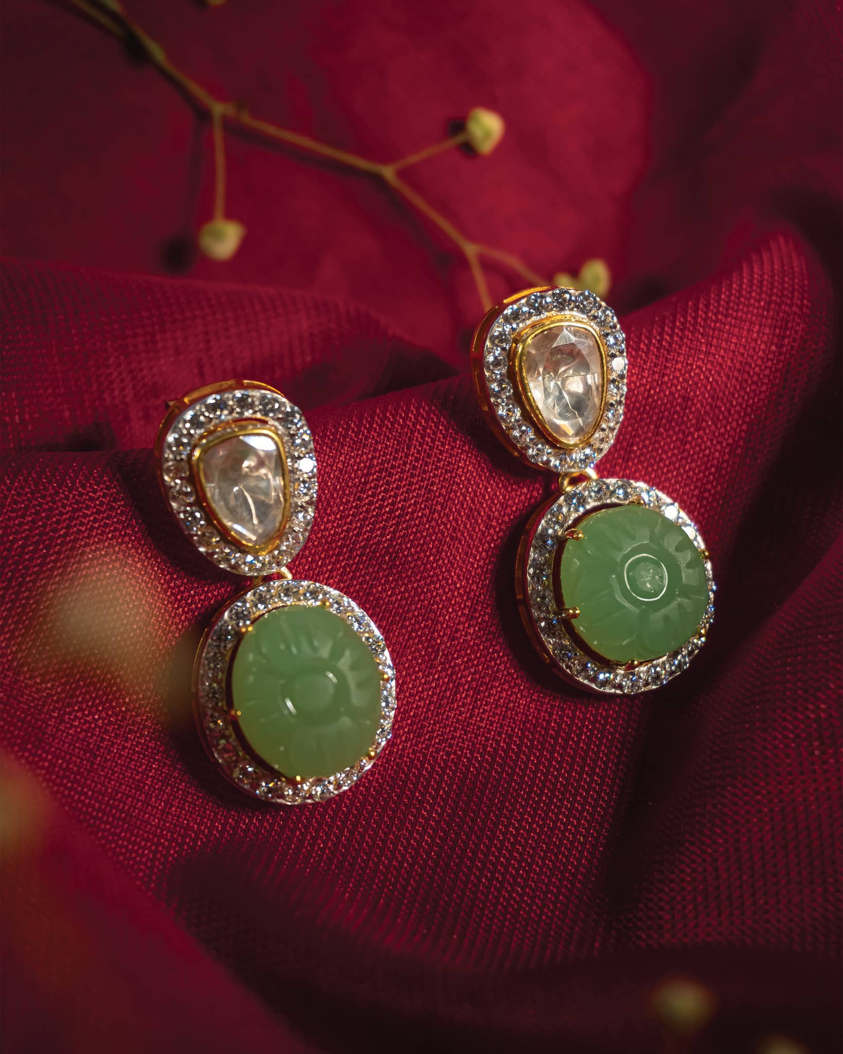 Gold plated 925 silver drop earrings featuring a carved green melon-cut stone surrounded by american diamonds and polki stud.