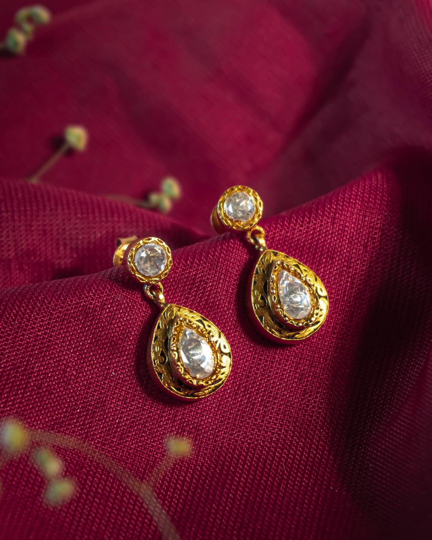 Gold plated 925 silver teardrop earrings featuring polki stones and intricate antique scrollwork engraving.