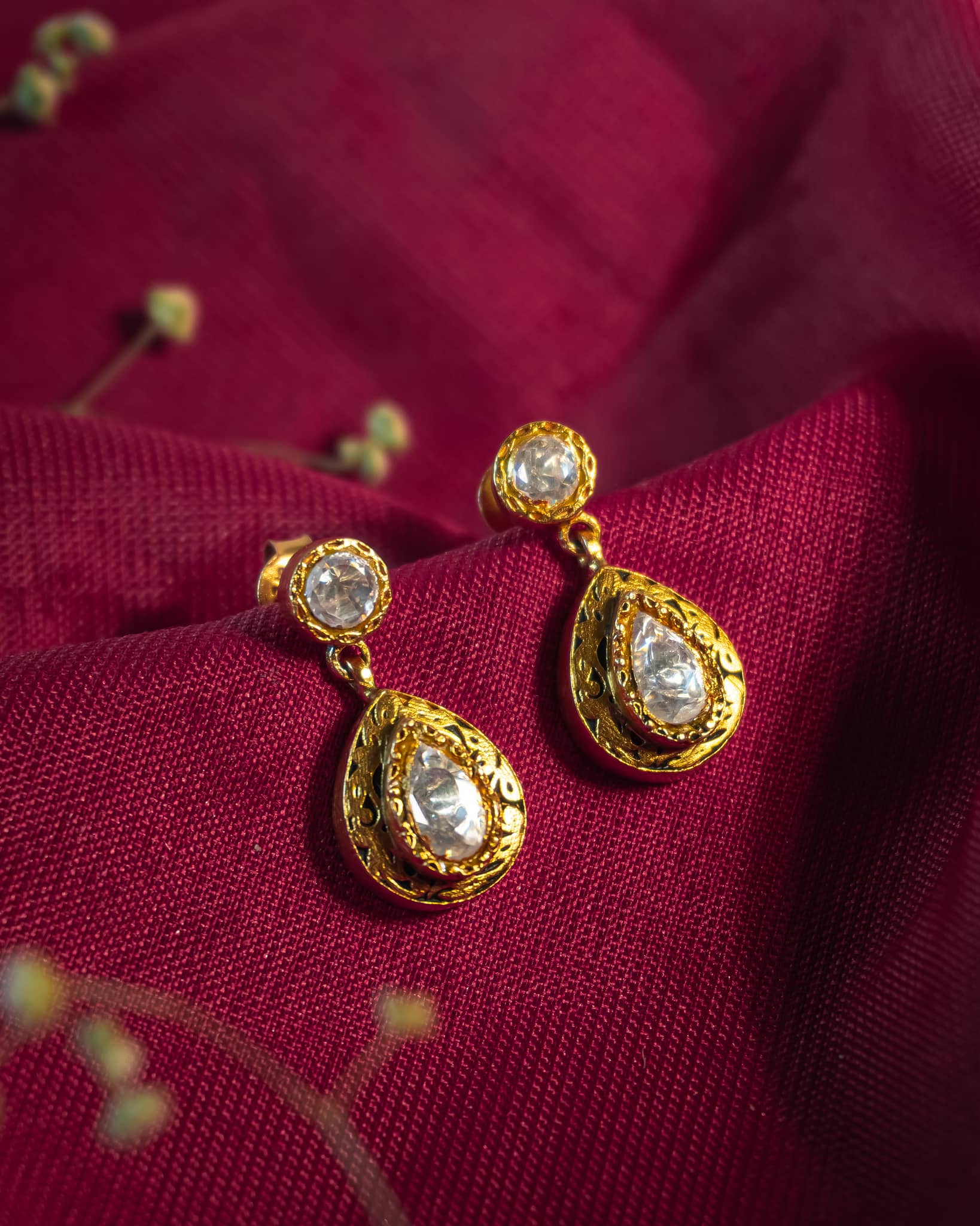 Gold plated 925 silver teardrop earrings featuring polki stones and intricate antique scrollwork engraving.