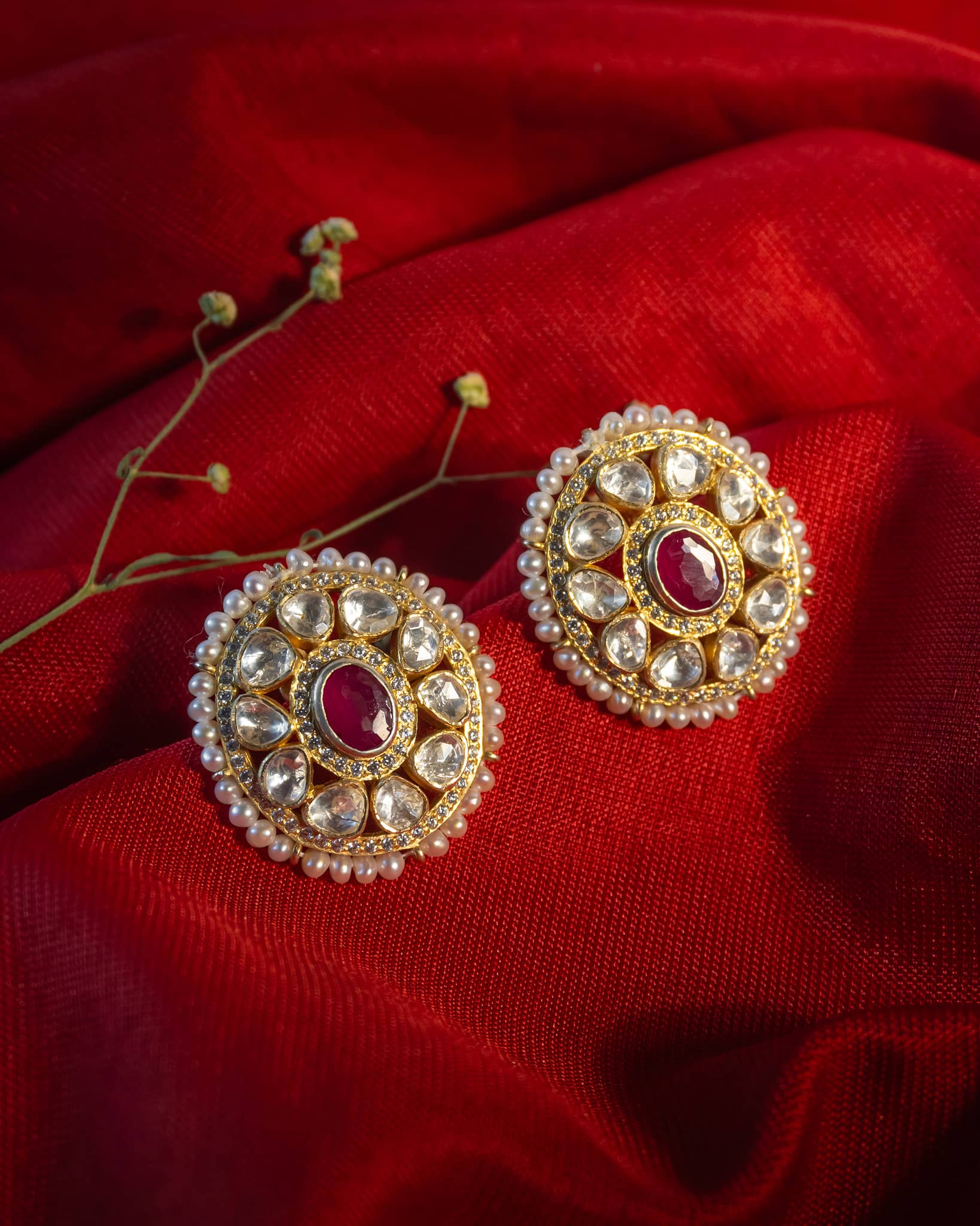 Gold plated round polki stud earrings featuring a ruby center and pearl border.