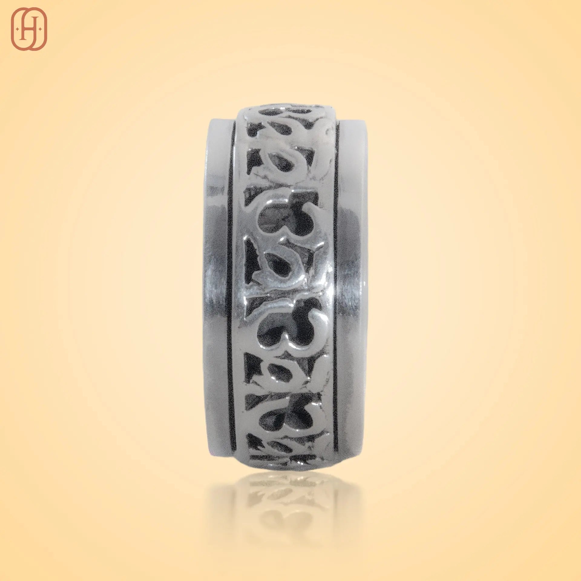 Silver Om Band jewelry with intricate carved design by Hardik Jewels on a beige background