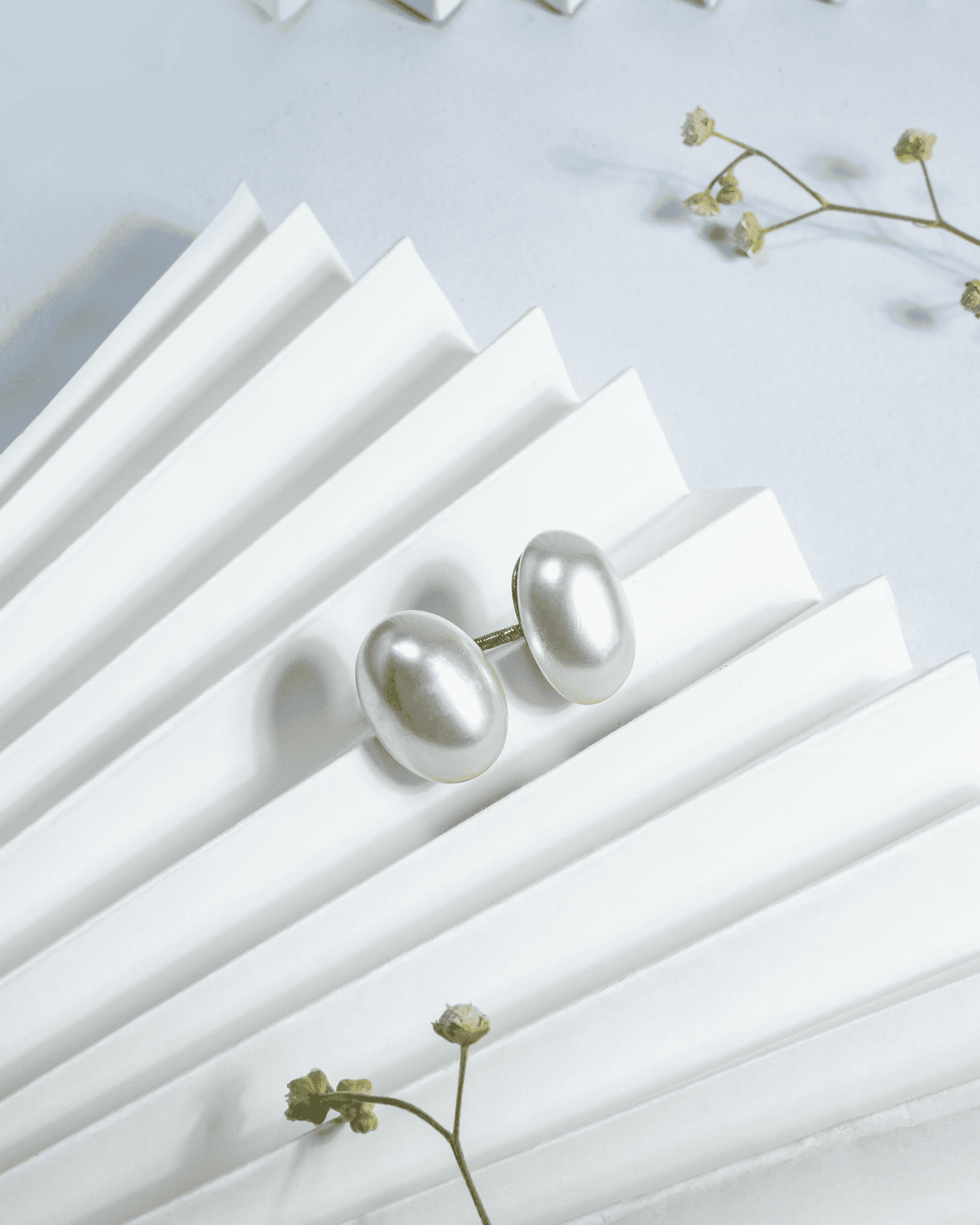 Large white button pearl stud earrings featuring a secure screw-back mechanism.