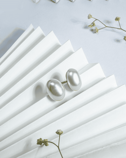 Large white button pearl stud earrings featuring a secure screw-back mechanism.