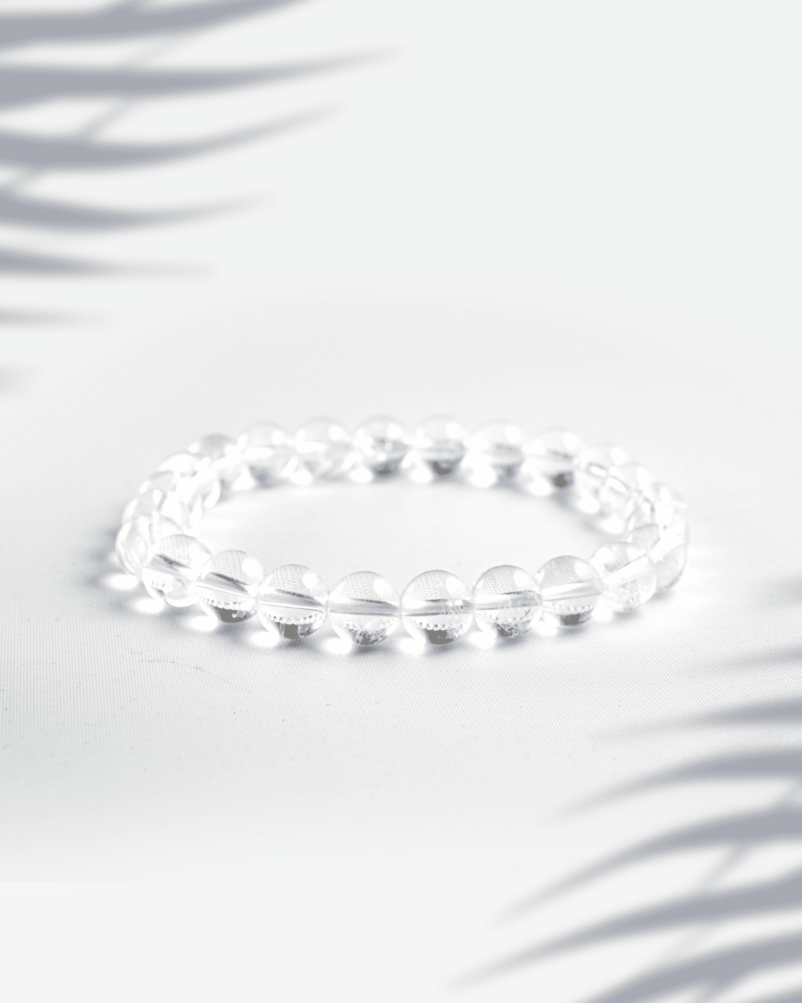 Natural Clear Quartz (Sphatik) gemstone bracelet featuring transparent round beads on a white background.