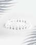 Natural Clear Quartz (Sphatik) gemstone bracelet featuring transparent round beads on a white background.