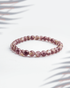 Natural Lepidolite gemstone bracelet featuring 6mm faceted purple beads on a white background.