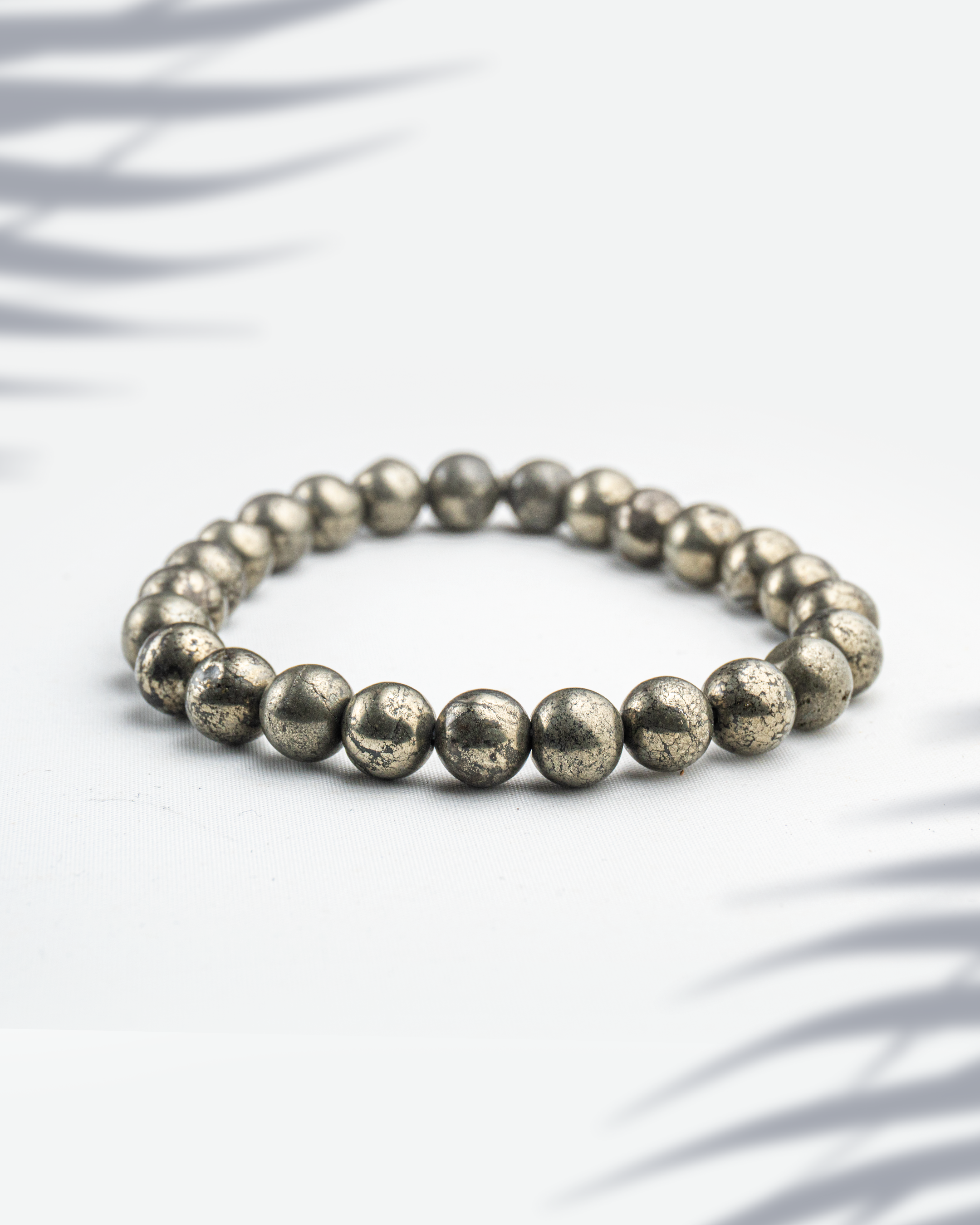 Natural Pyrite gemstone bracelet featuring metallic golden beads on a white background.