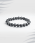 Natural black lava stone bracelet featuring porous volcanic beads on a white background.