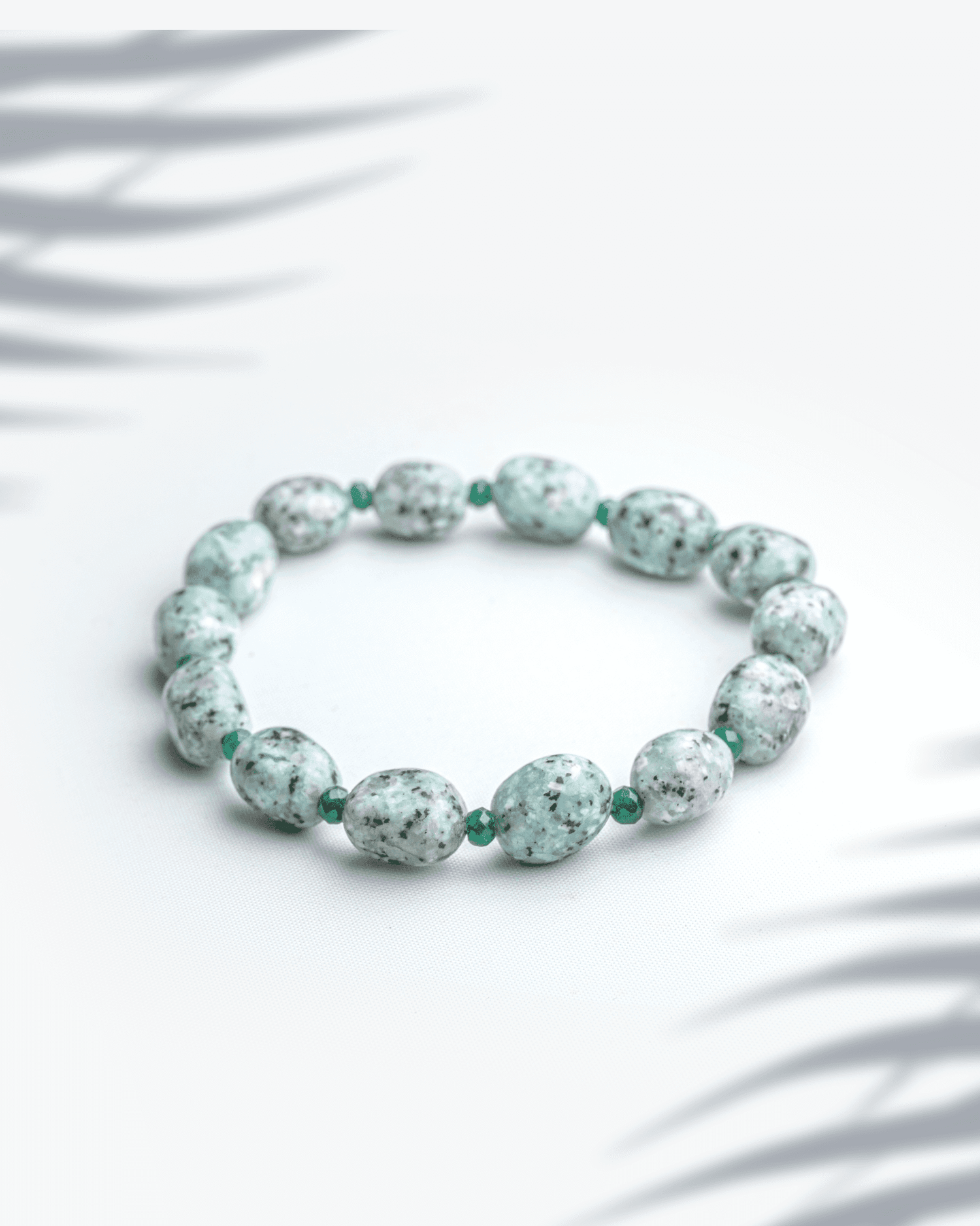 Natural kiwi moonstone bracelet featuring 7mm mint green sesame jasper beads with black speckles.