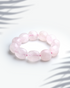 Natural rose quartz gemstone bracelet featuring organic tumbled pink nugget beads on a white background