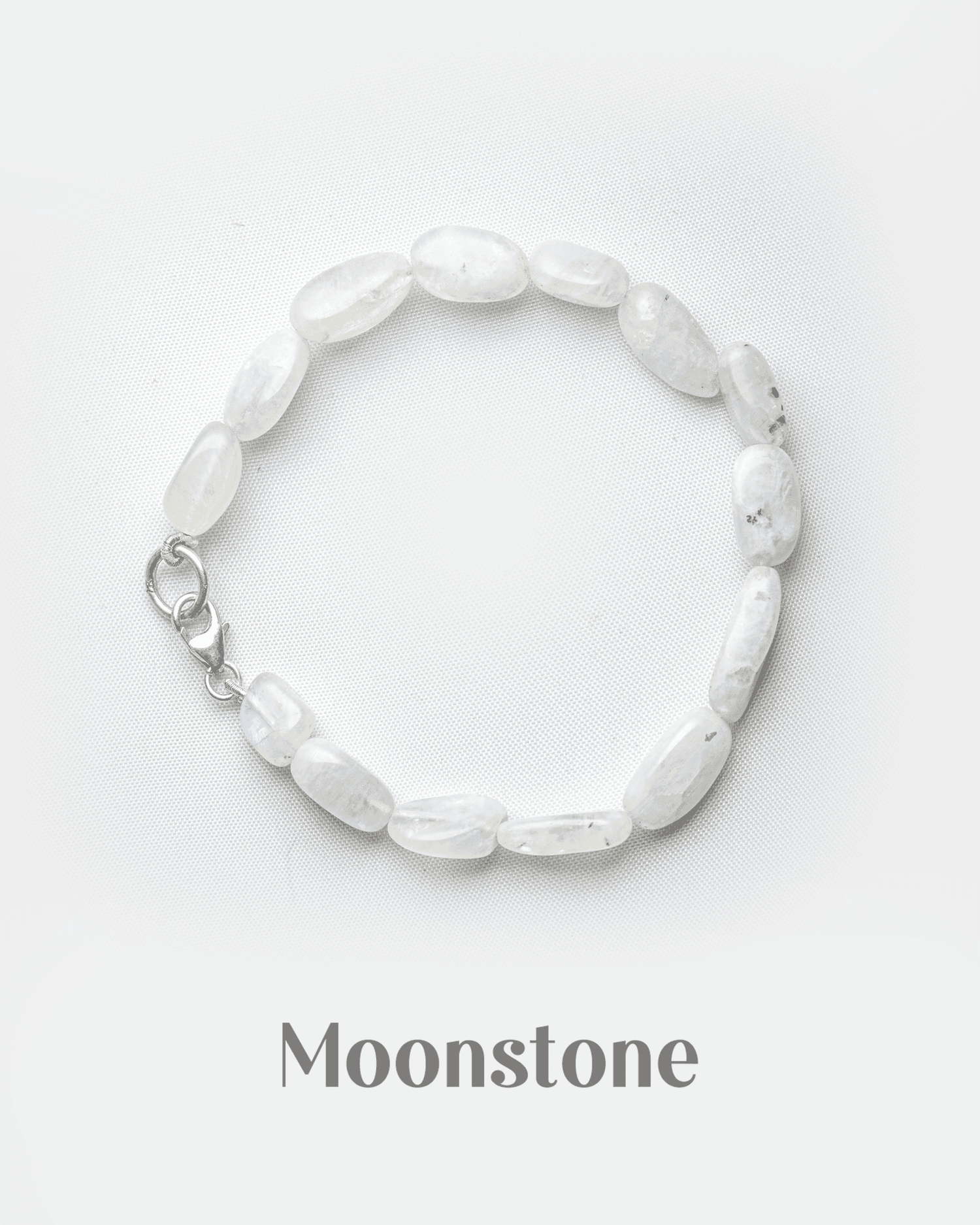 Natural white rainbow moonstone bracelet with silver lobster clasp featuring smooth milky oval beads.