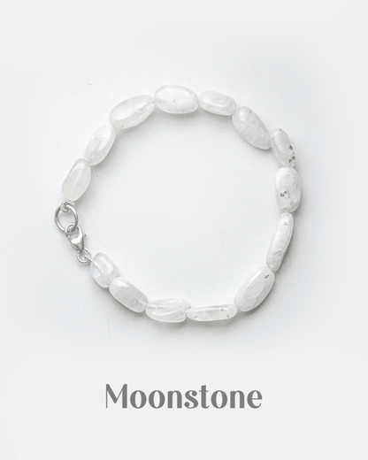 Natural white rainbow moonstone bracelet with silver lobster clasp featuring smooth milky oval beads.