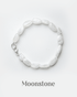 Natural white rainbow moonstone bracelet with silver lobster clasp featuring smooth milky oval beads.