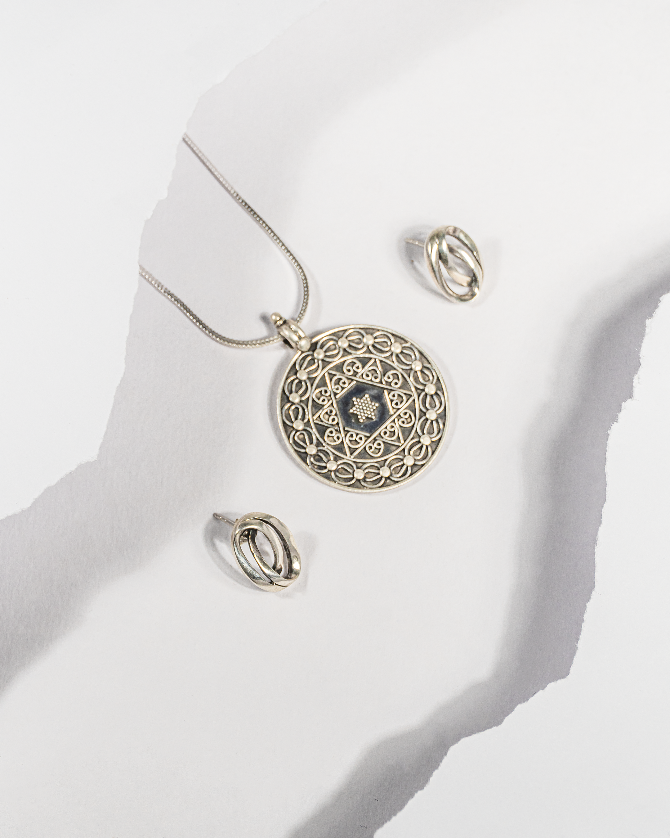 Oxidized 925 sterling silver circular mandala pendant with star design and simple knot stud earrings (chain not included).