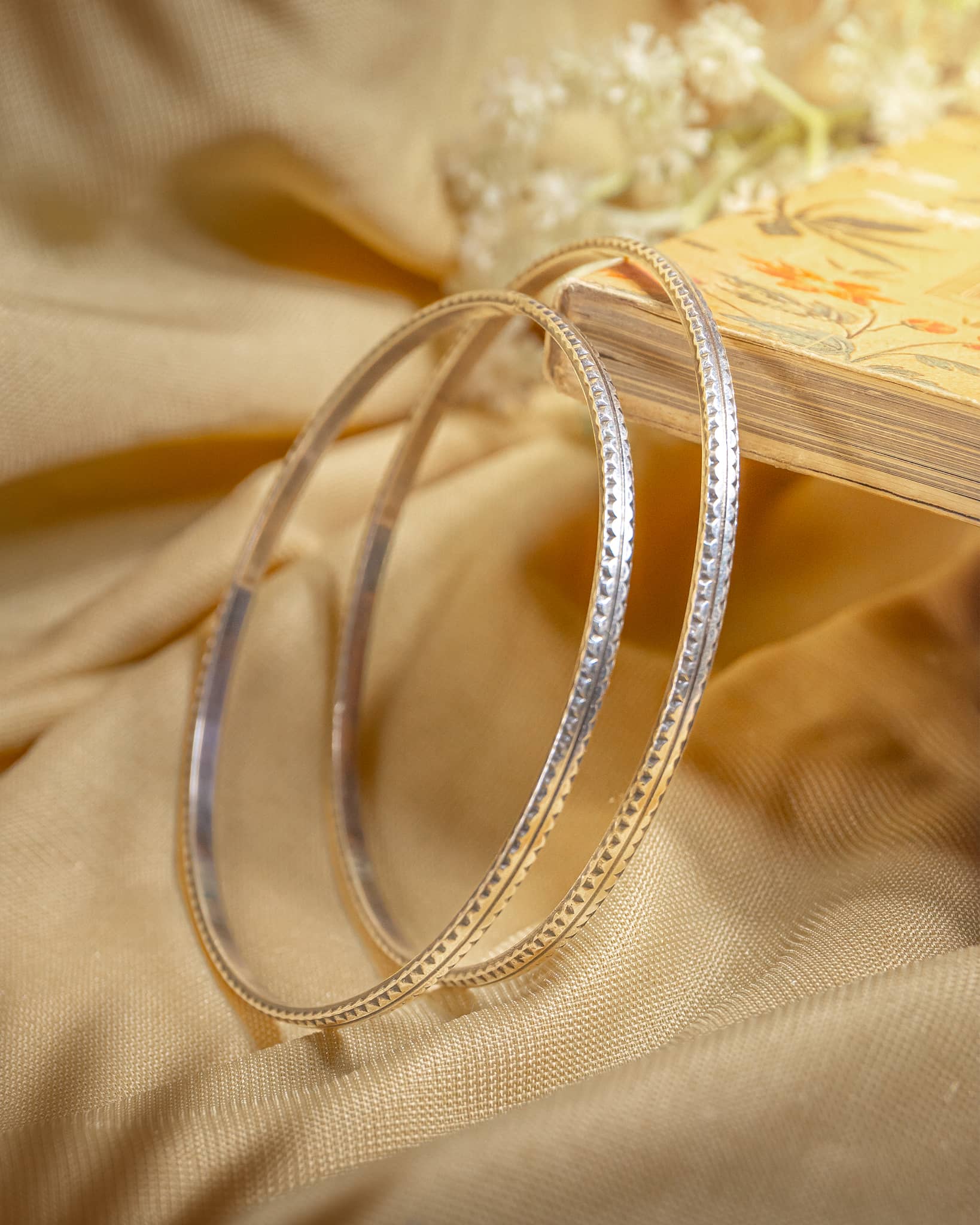 Pair of 92.5 sterling silver bangles featuring diamond cut textured