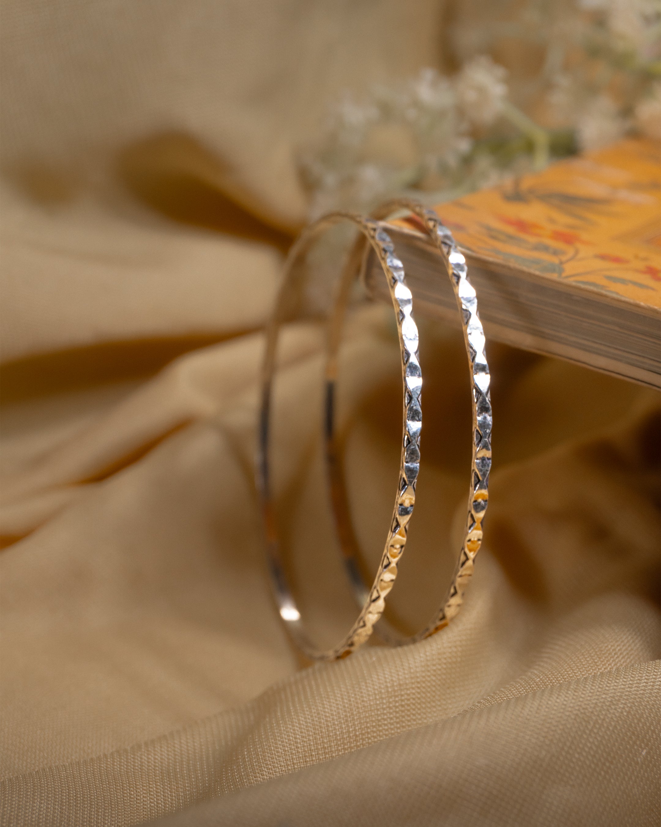 Pair of 92.5 sterling silver bangles featuring diamond cut textured design for sparkle.