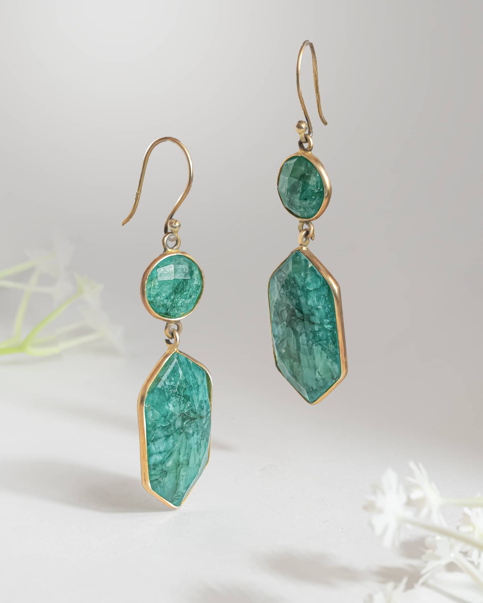 Pair of bohemian 92.5 sterling silver gold plated dangle earrings featuring raw textured green stones in round and hexagonal shapes.