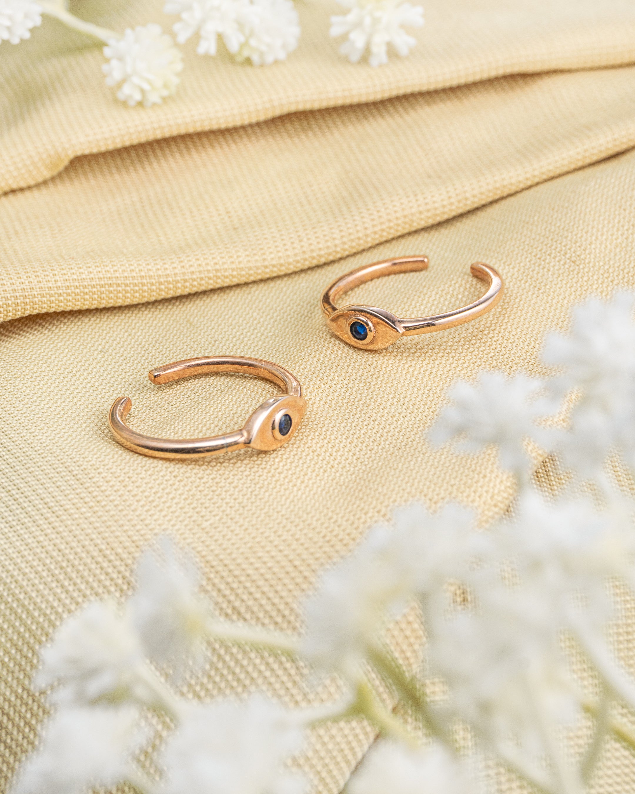 Pair of gold plated 92.5 sterling silver adjustable toe rings featuring an evil eye design with blue stone.