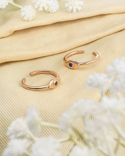 Pair of gold plated 92.5 sterling silver adjustable toe rings featuring an evil eye design with blue stone.