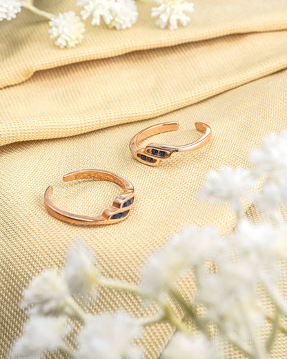 Pair of gold plated 92.5 sterling silver adjustable toe rings featuring blue stones in a wave design.