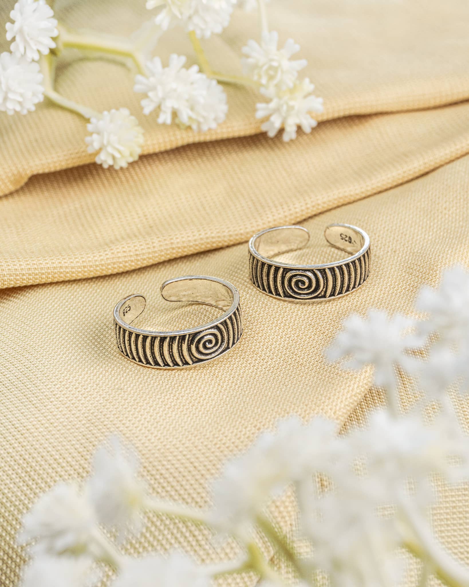 Pair of oxidized 92.5 sterling silver band toe rings featuring a spiral swirl design.