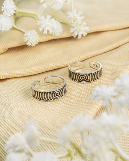 Pair of oxidized 92.5 sterling silver band toe rings featuring a spiral swirl design.