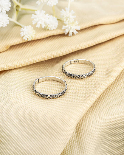 Pair of oxidized 92.5 sterling silver slim band toe rings featuring geometric etched design.