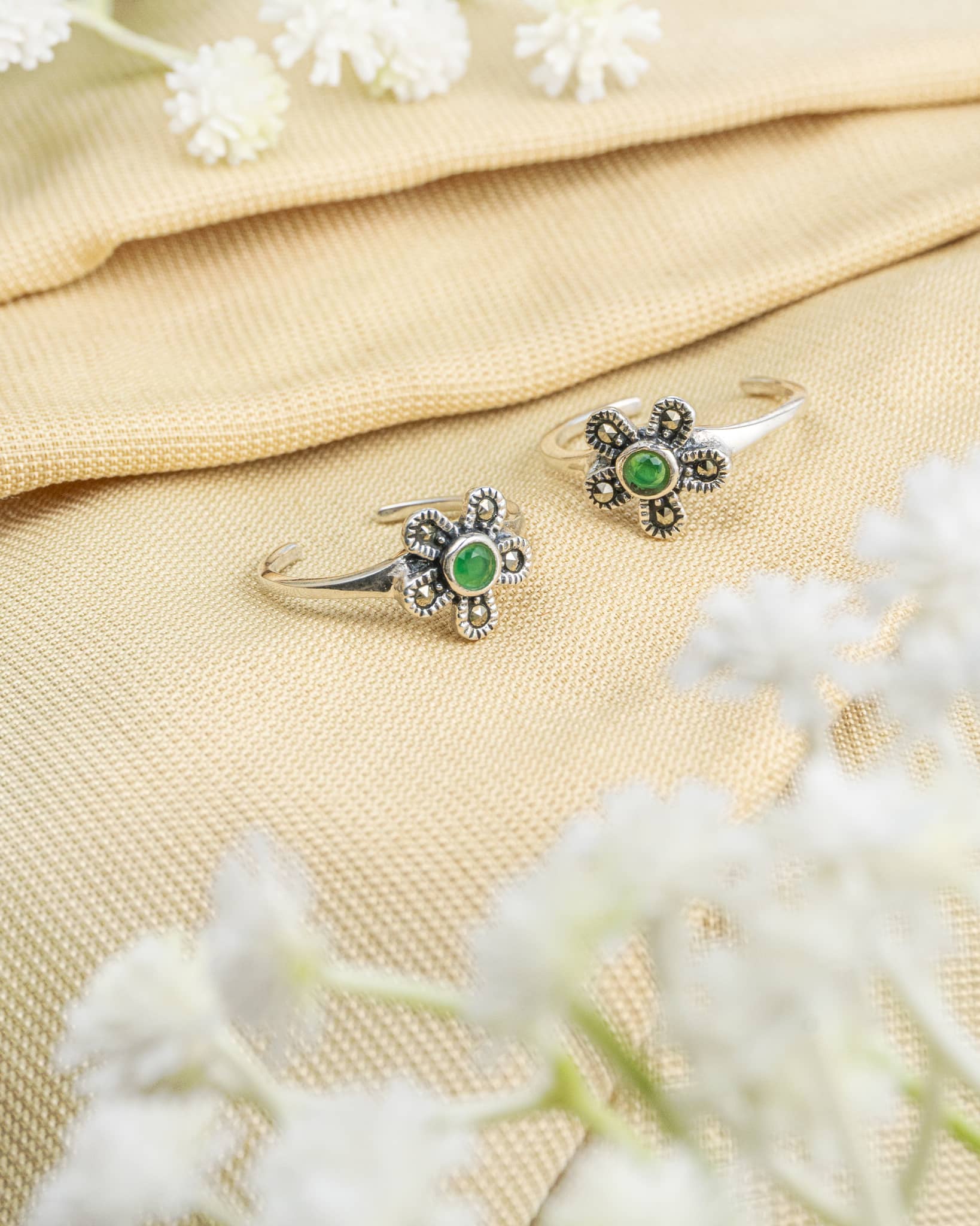 Pair of oxidized 92.5 sterling silver toe rings featuring a green stone floral design.