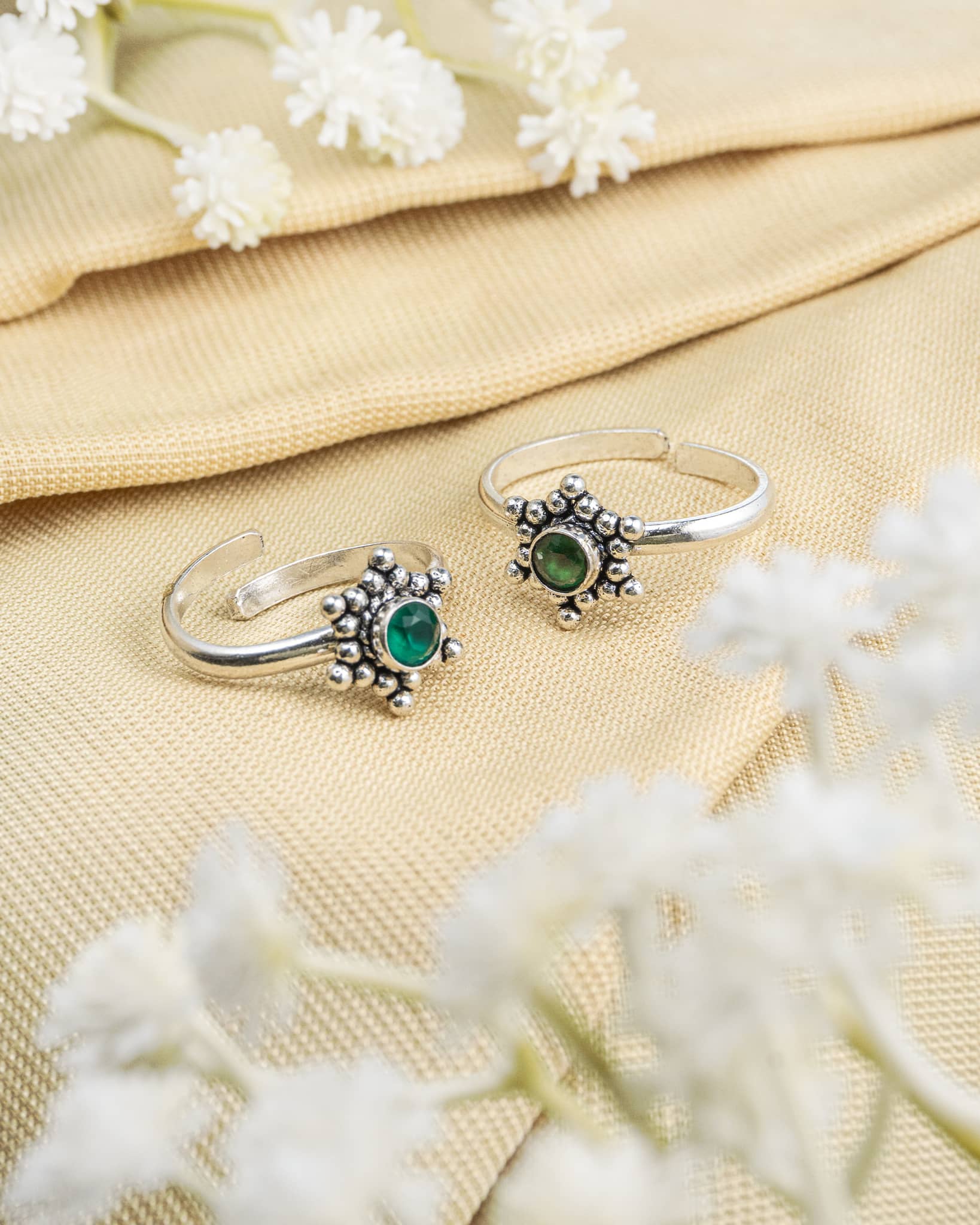 Pair of oxidized 92.5 sterling silver toe rings featuring a green stone with beaded sunburst design.