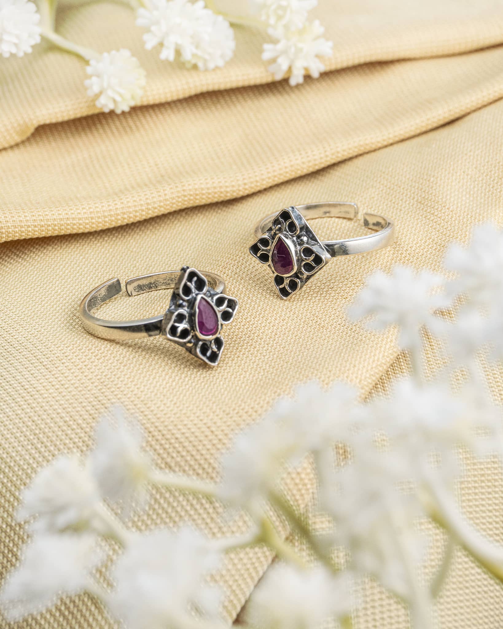 Pair of oxidized 92.5 sterling silver toe rings featuring a purple stone diamond design.