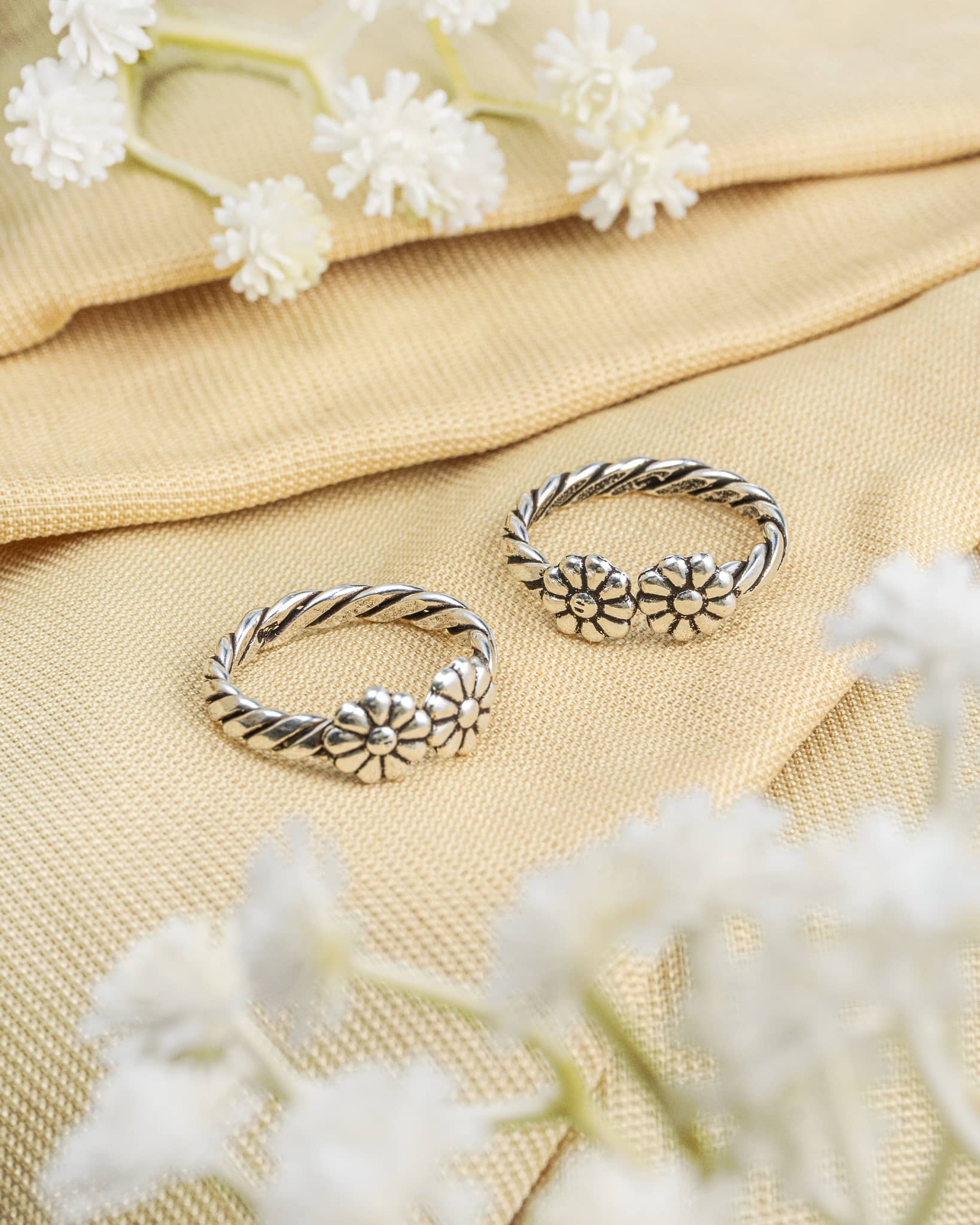 Pair of oxidized 92.5 sterling silver toe rings featuring a twisted rope band with double flower design.