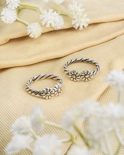 Pair of oxidized 92.5 sterling silver toe rings featuring a twisted rope band with double flower design.