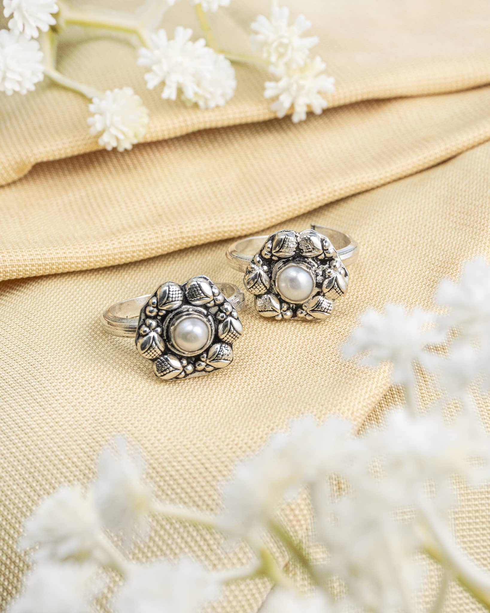 Pair of oxidized 92.5 sterling silver toe rings featuring a white pearl floral design.