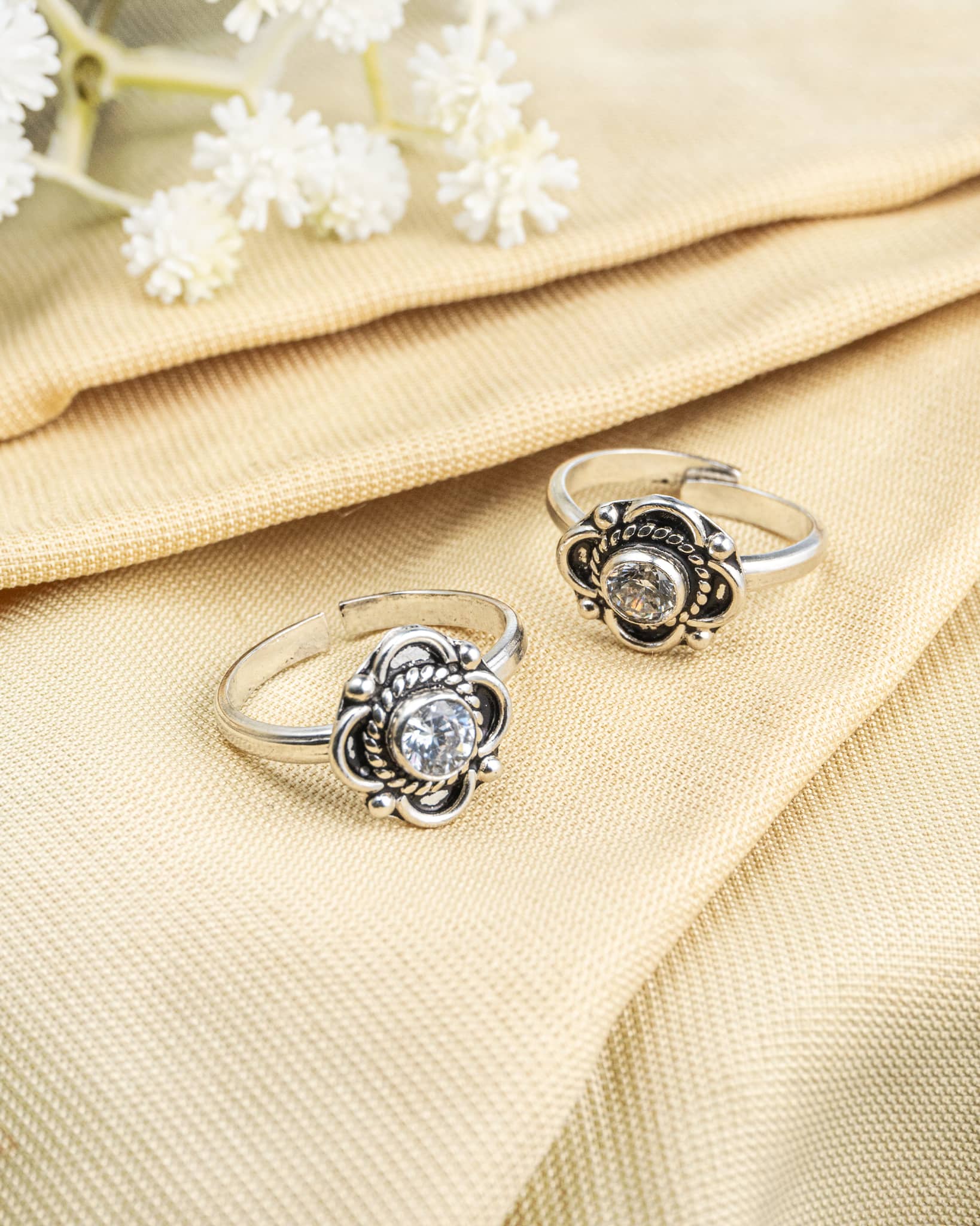 Pair of oxidized 92.5 sterling silver toe rings featuring a white stone floral mandala design.