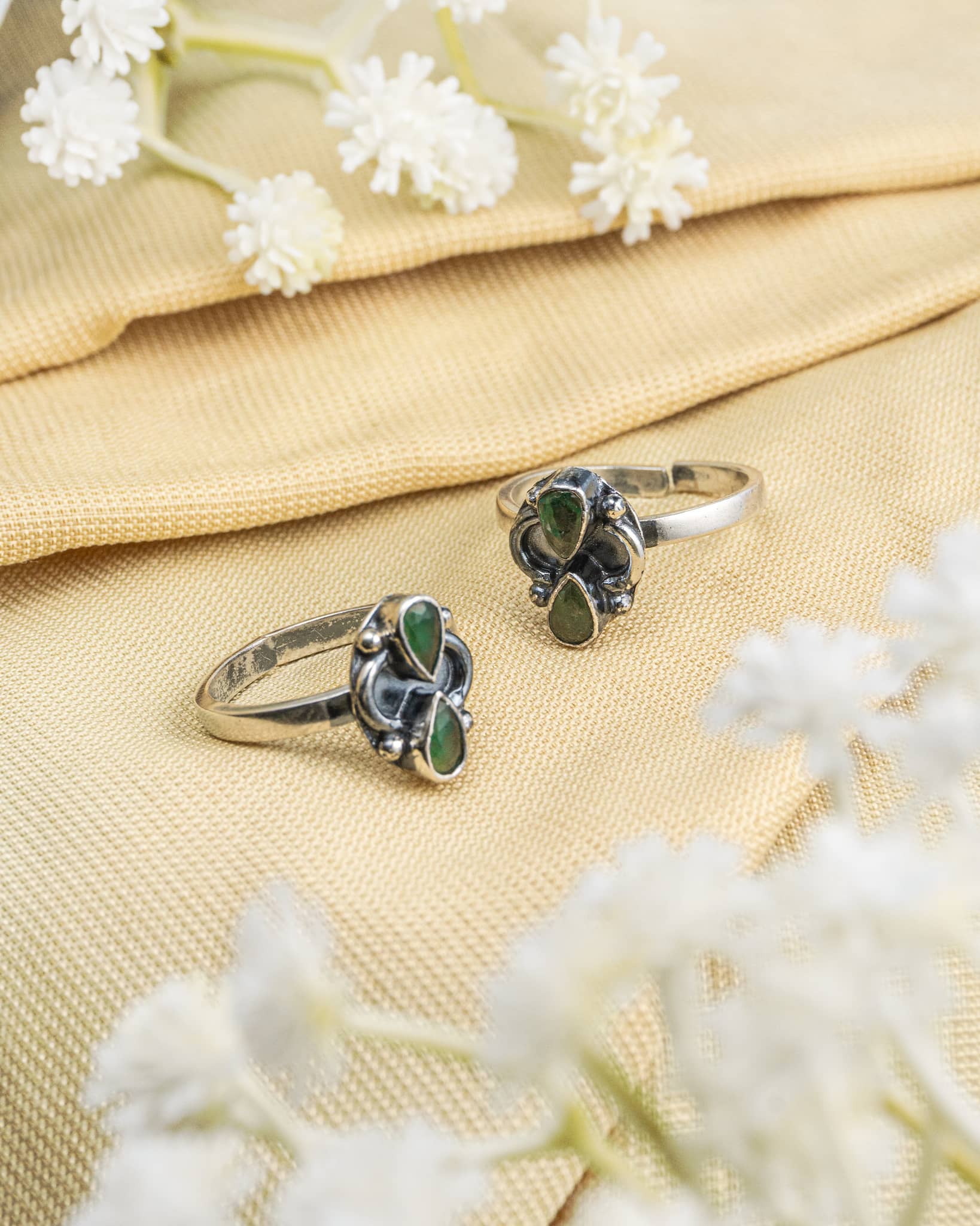 Pair of oxidized 92.5 sterling silver toe rings featuring two green pear shaped stones.