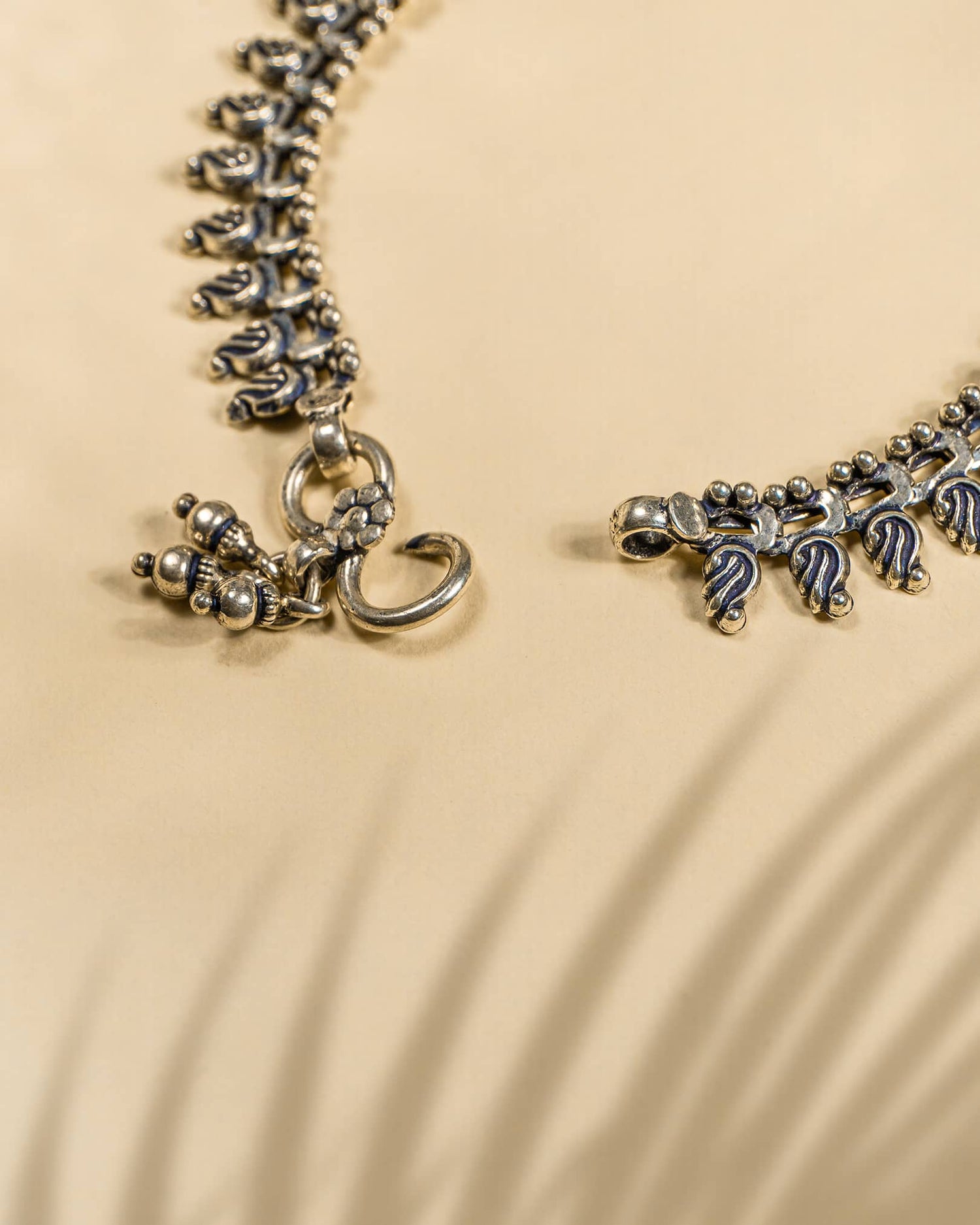 Pair of traditional oxidized silver anklets featuring repeating paisley mango motifs and small silver beads lock