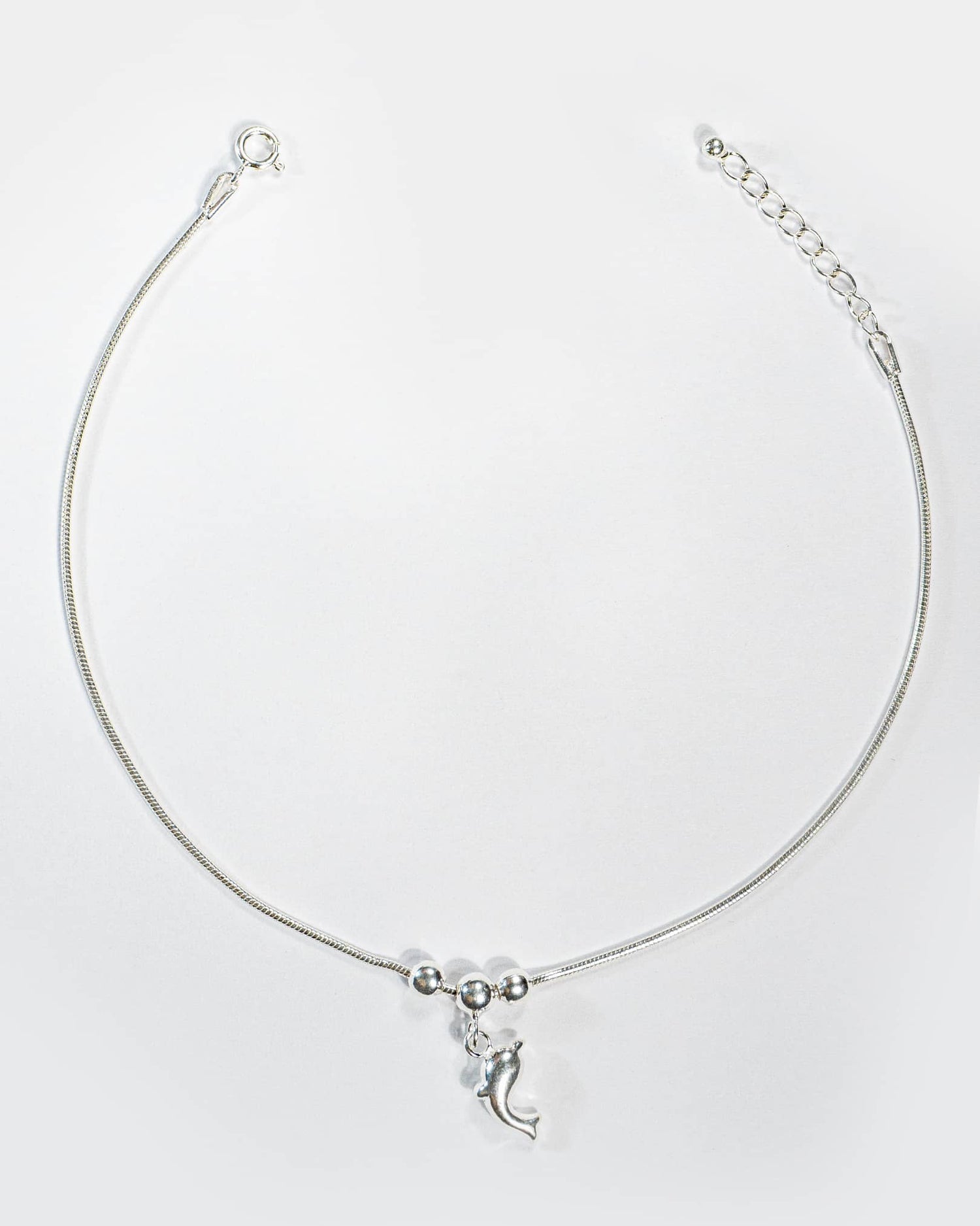 Silver Anklet with a crescent Dolphin charm on a white background