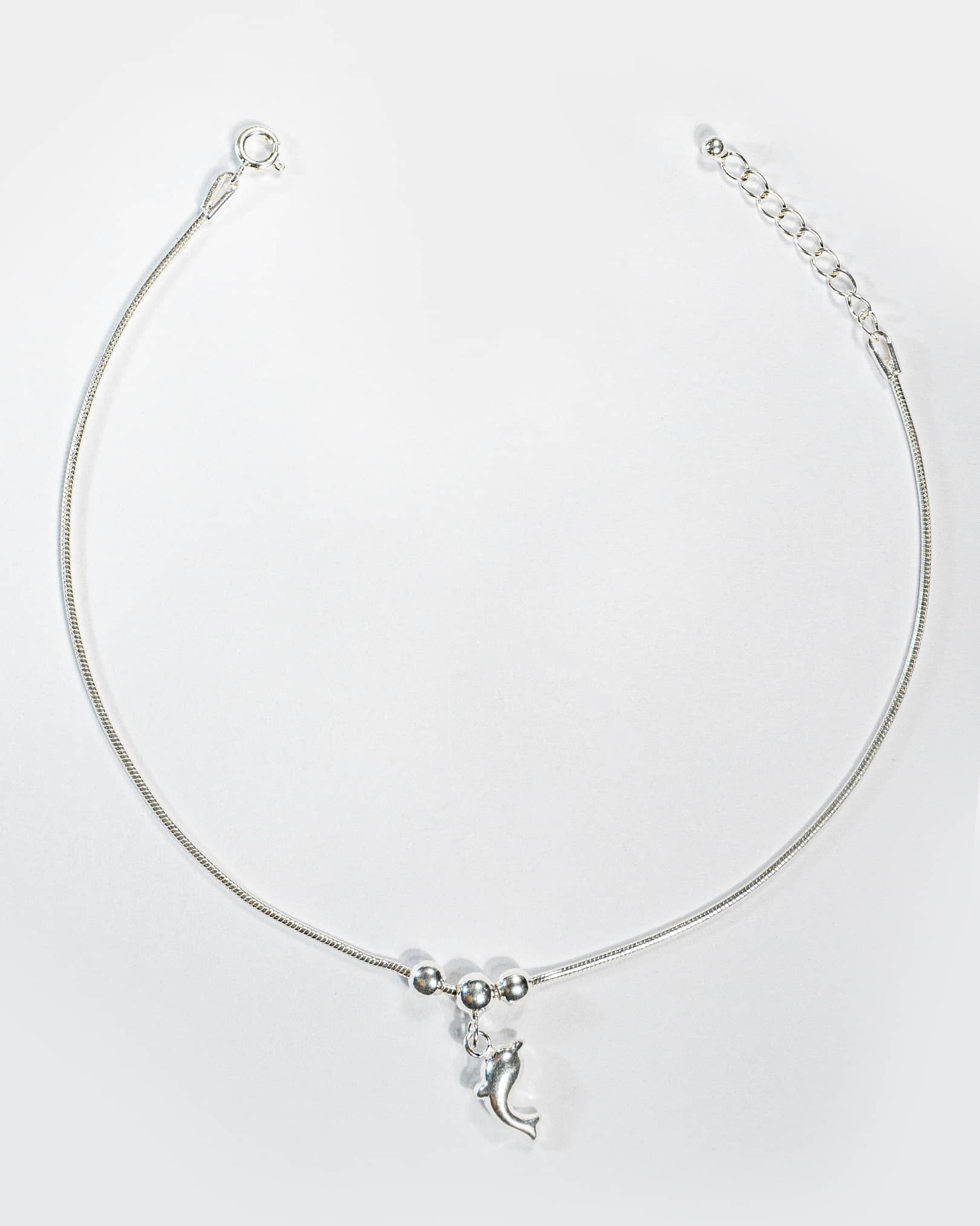 Silver Anklet with a crescent Dolphin charm on a white background