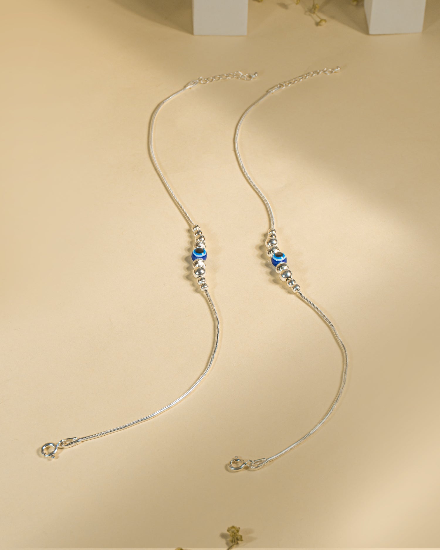 925 Sterling Silver Nazariya Payal featuring a blue evil eye bead on a snake chain, isolated on white background.