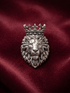 Oxidized 925 silver royal crowned lion brooch on maroon fabric
