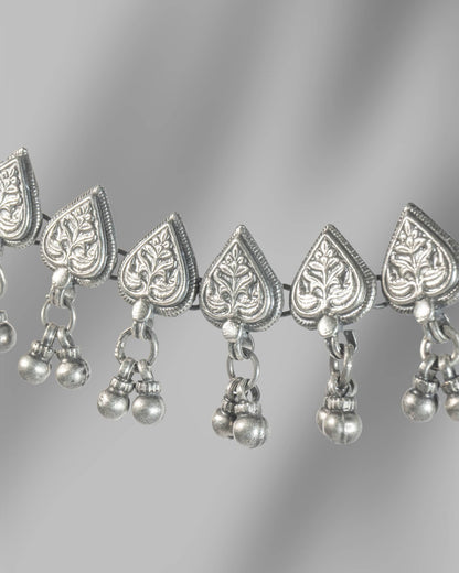 Silver necklace with heart-shaped pendants and hanging beads on a gray background