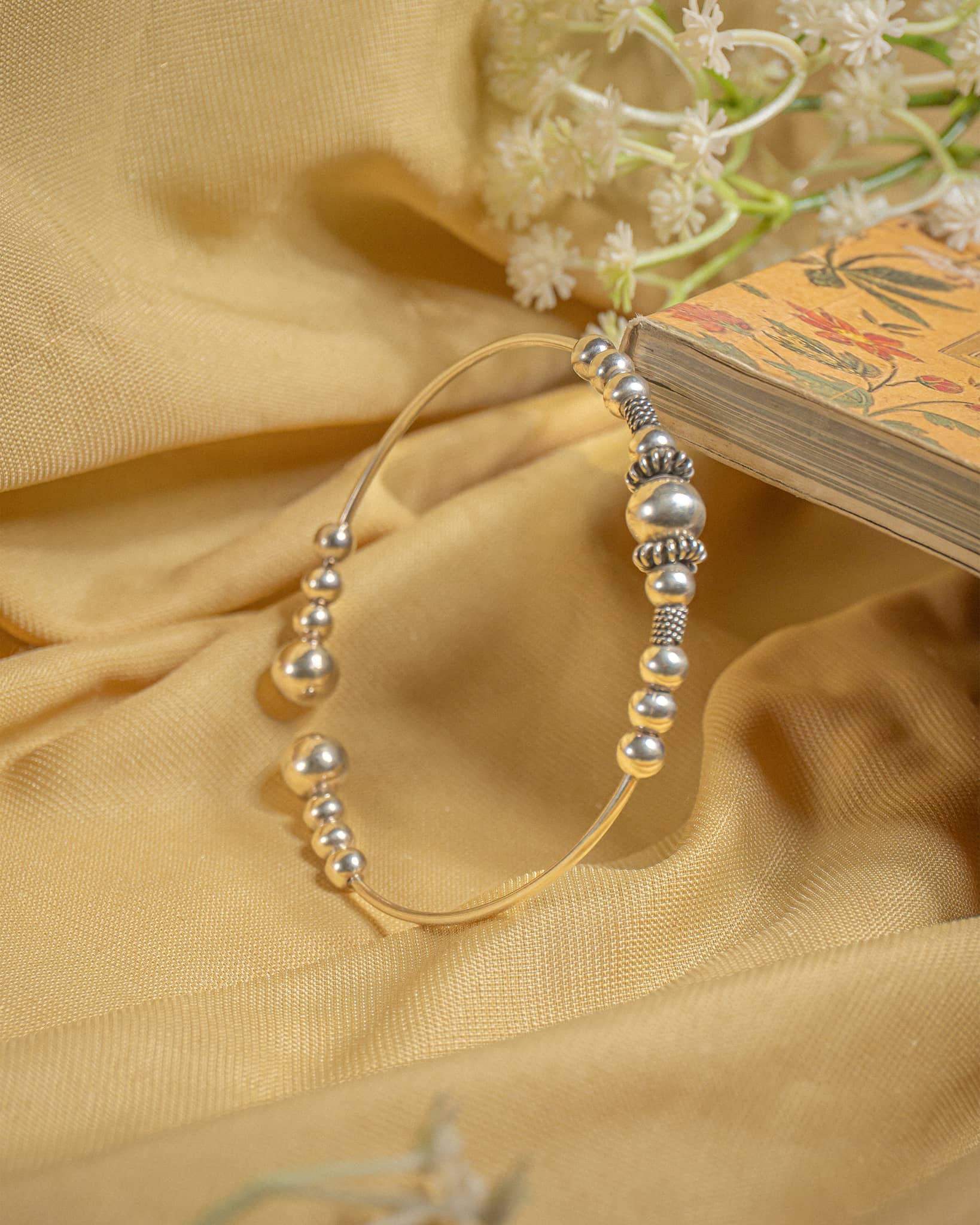 Silver open cuff bangle featuring graduated metal beads in a tribal boho design.