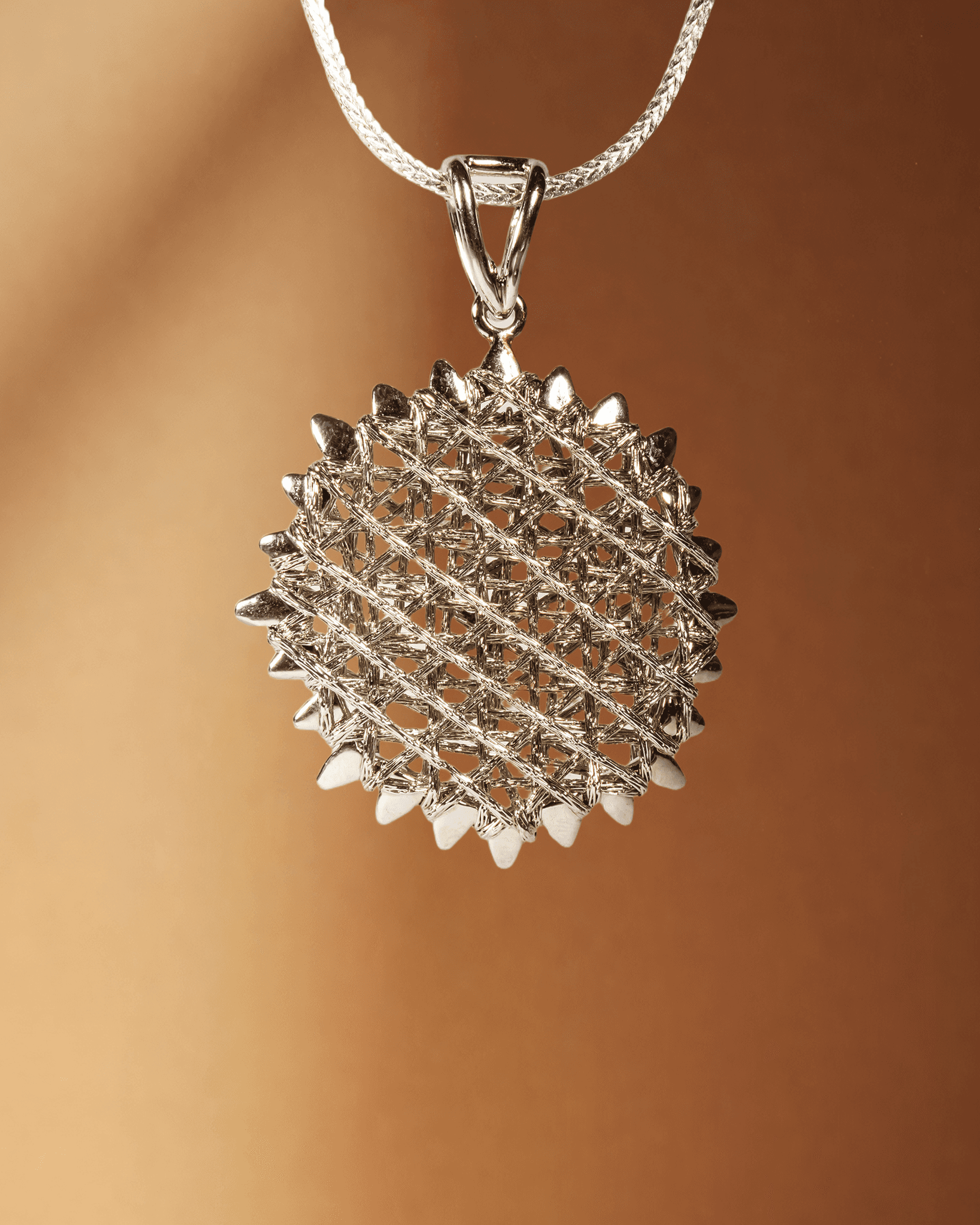 Silver textured pendant on a brown background