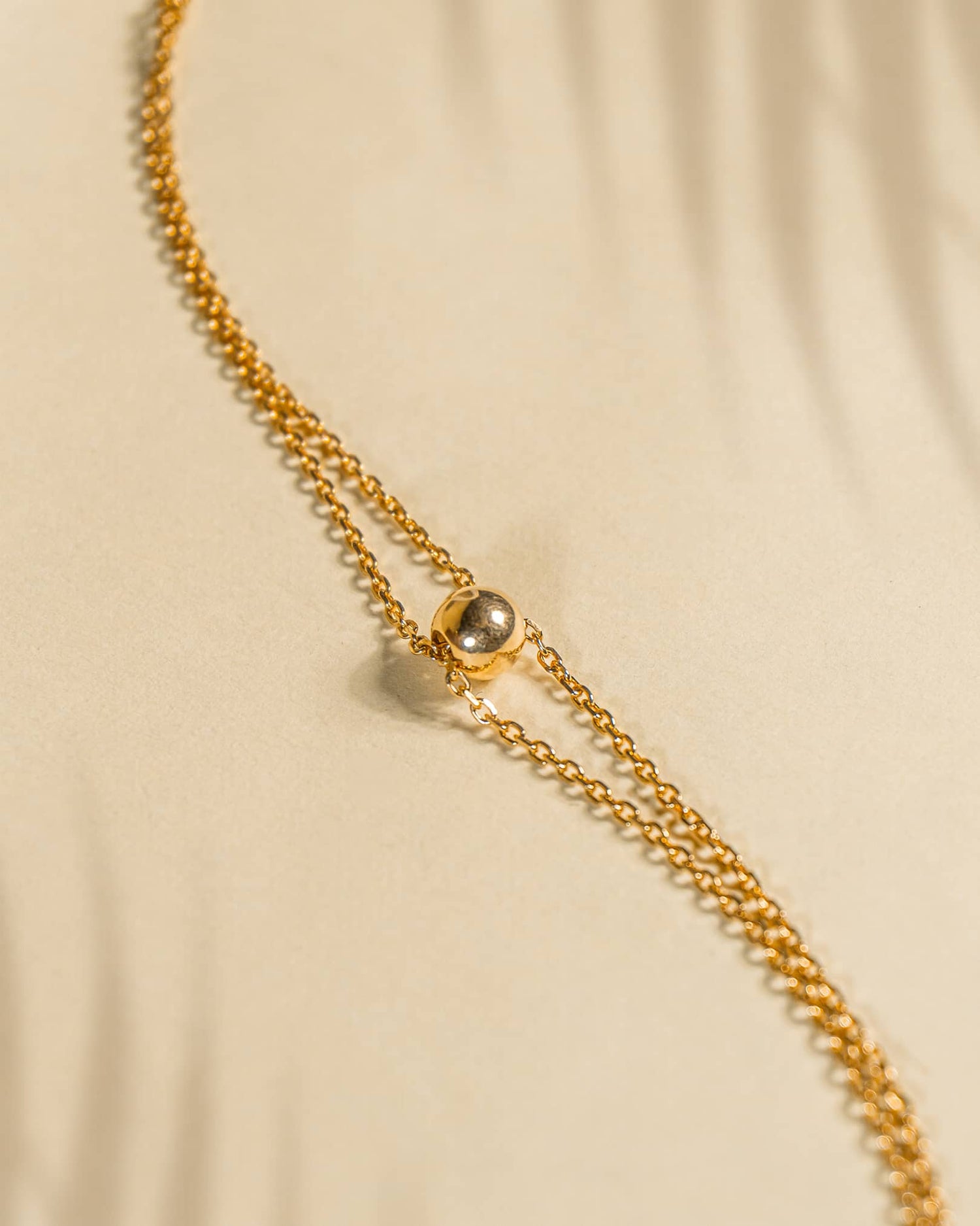 Single 18K gold plated silver anklet featuring a central polished gold ball on a delicate chain.