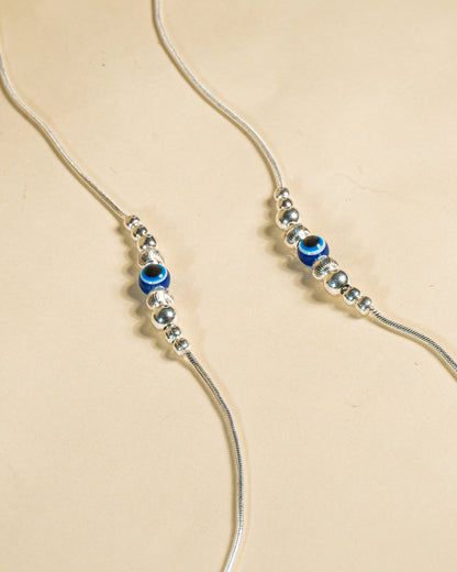 925 Sterling Silver Nazariya Payal featuring a blue evil eye bead on a snake chain, isolated on white background.