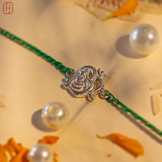 92.5 silver rakhi for brother with green braided thread and intricate silver Ganesh charm