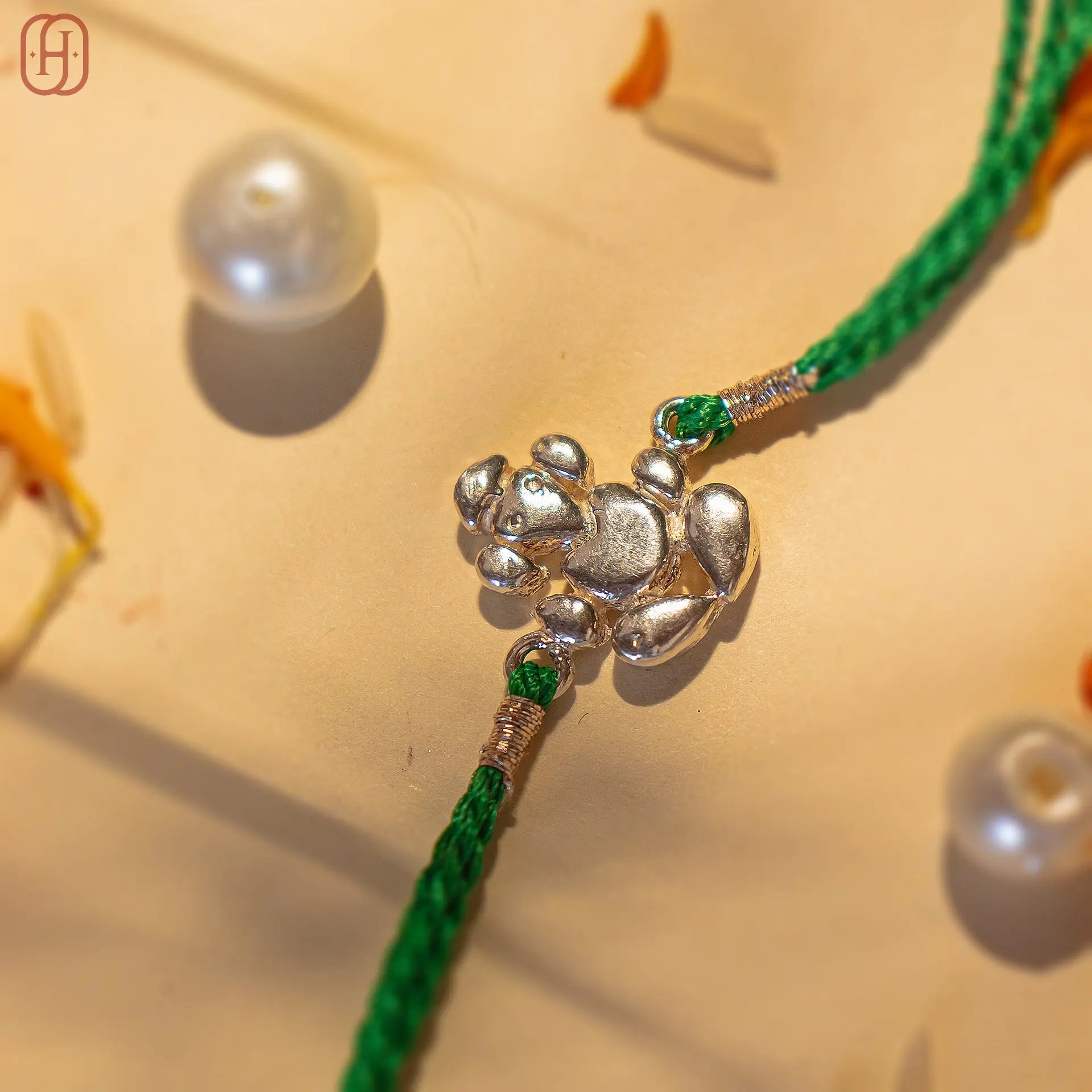 Ganesh Ji face silver rakhi online with intricate silver charm and green braided thread
