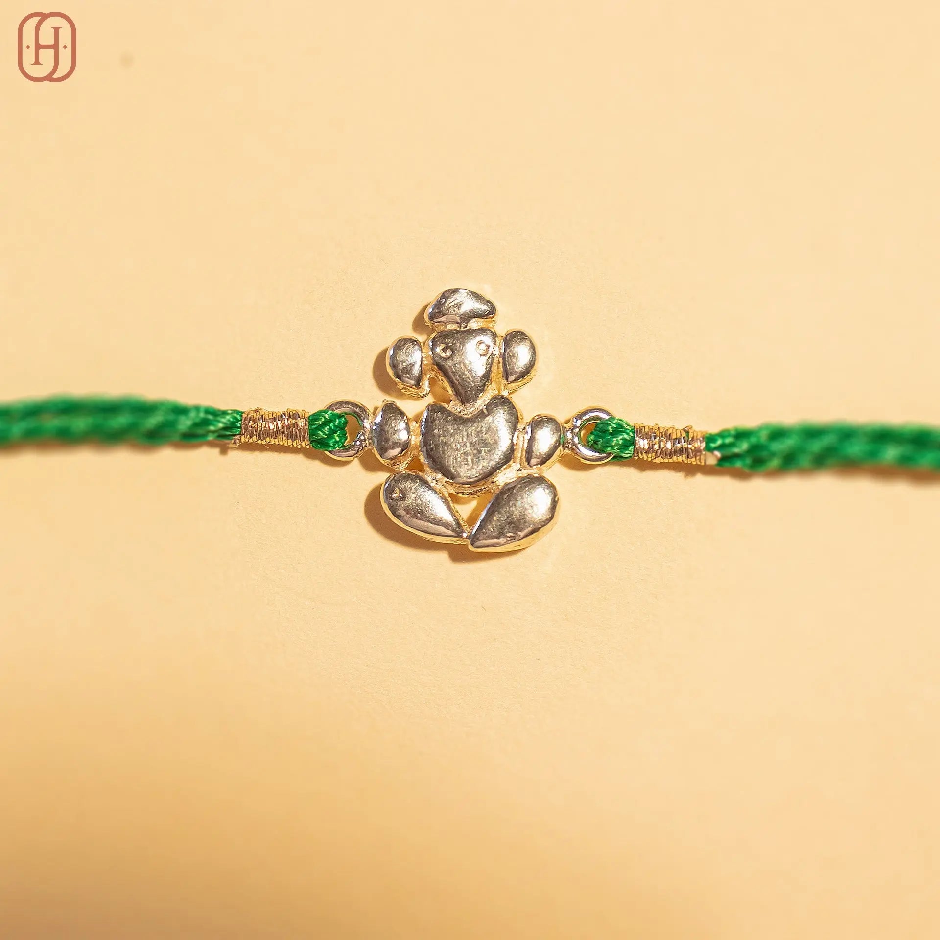 Ganesh Ji face silver rakhi online with detailed silver Ganesh charm and green thread by Hardik Jewels